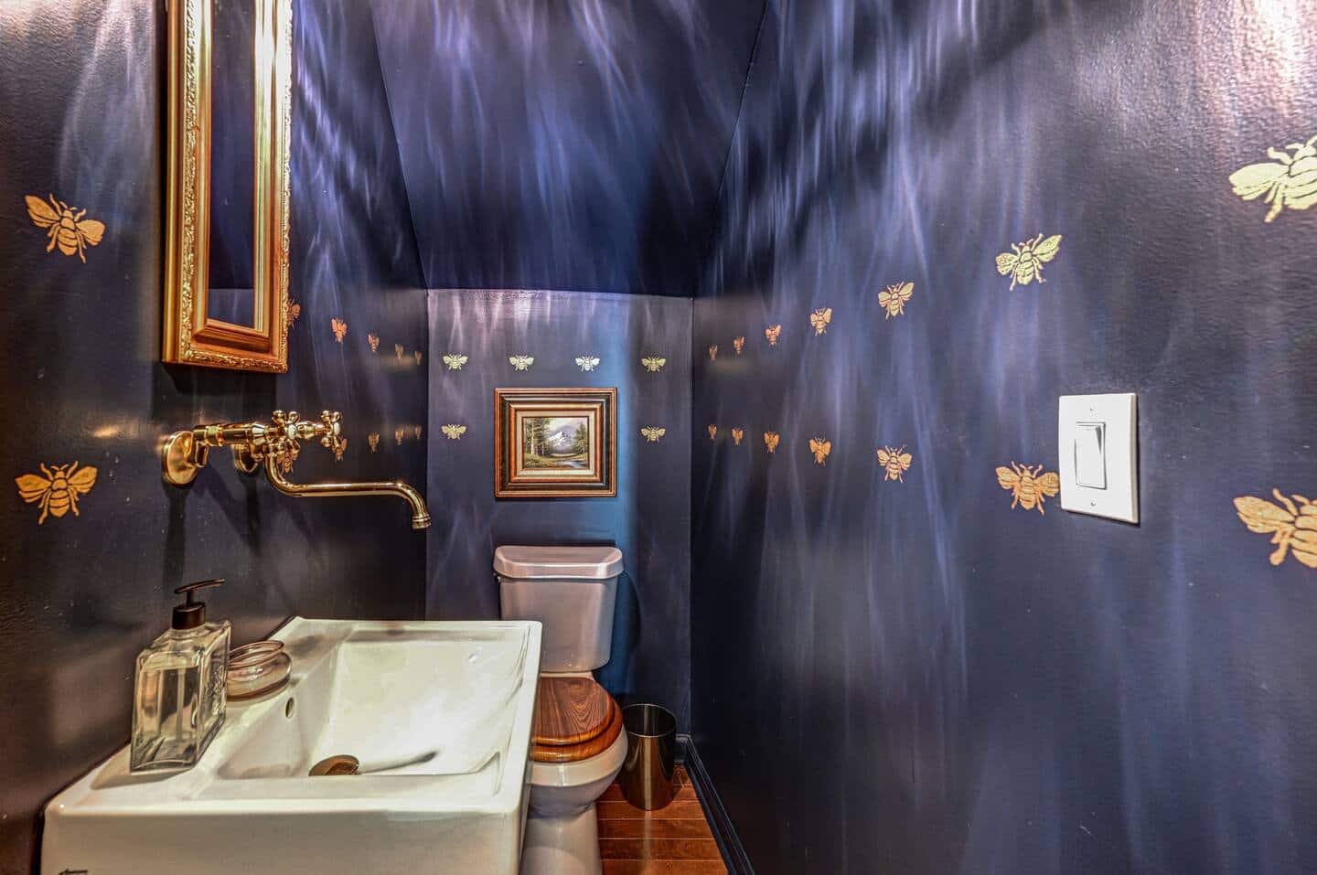 Gold bee powder room with brass fixtures