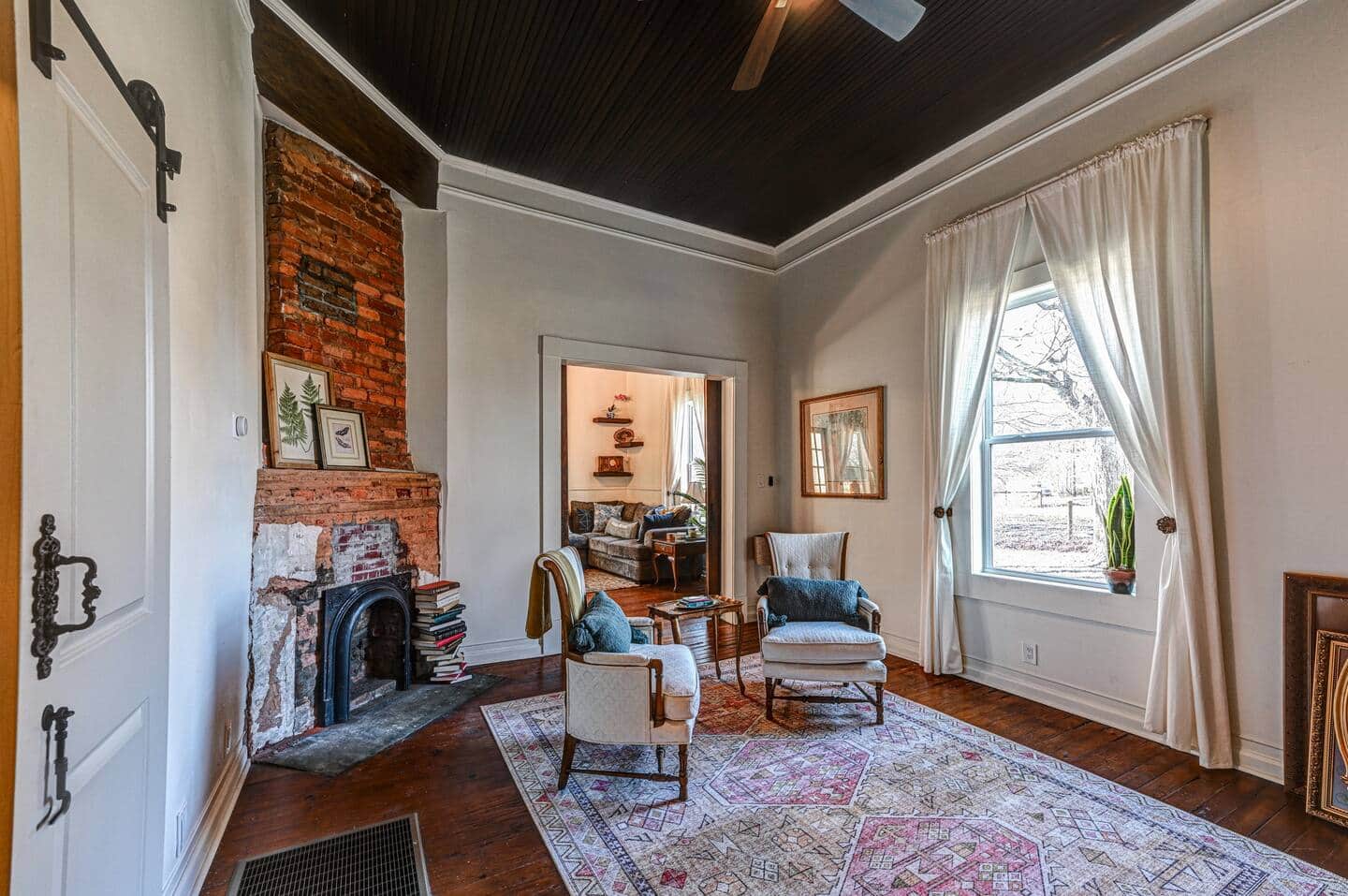 Sitting room with dark ceiling and brick fireplace