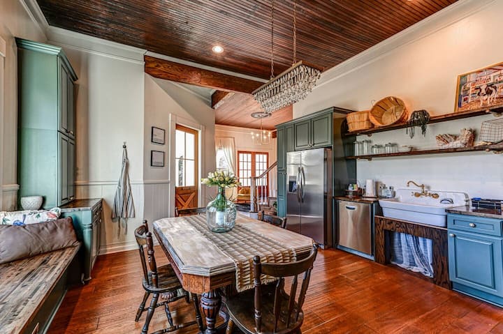 Homestead 180 kitchen — sage cabinets, wood ceiling, farm table