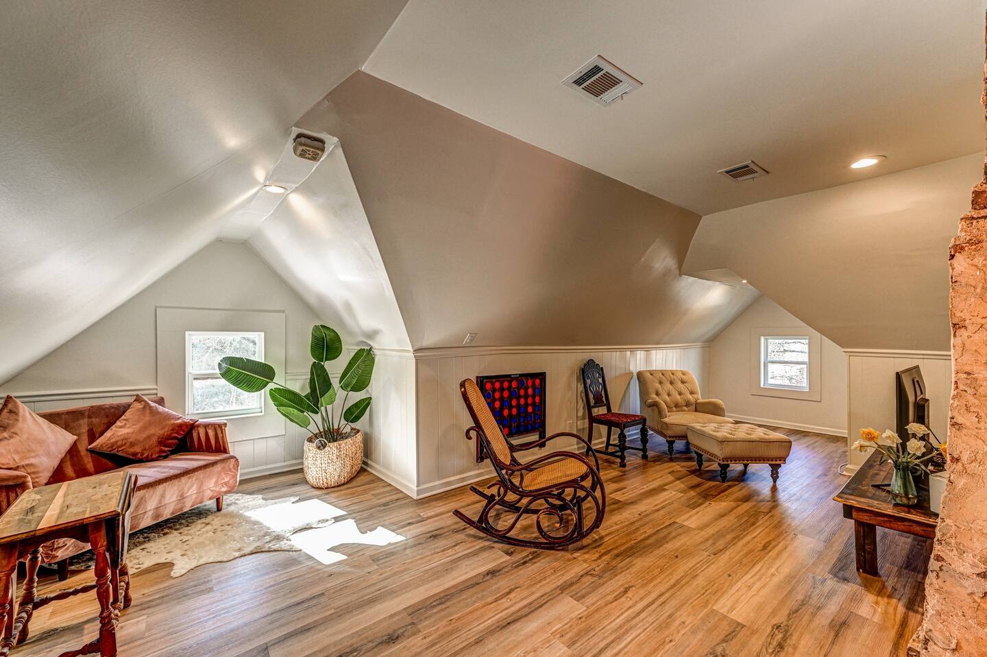 Attic lounge with rocking chair and exposed brick